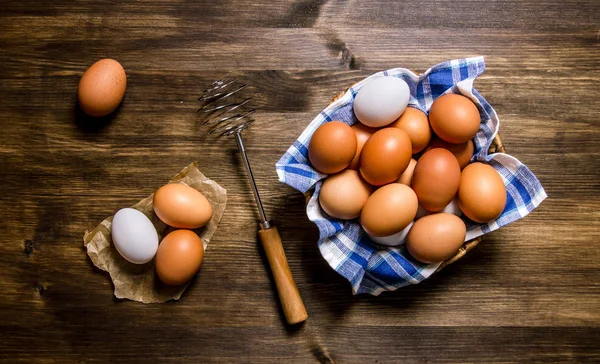 Eggs the background. The eggs in the bowl with the whisk.