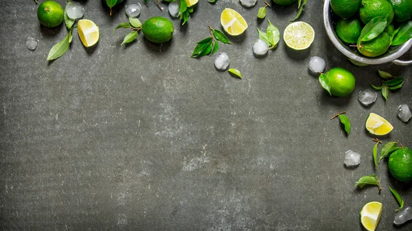 Lime background. Limes with leaves and ice.