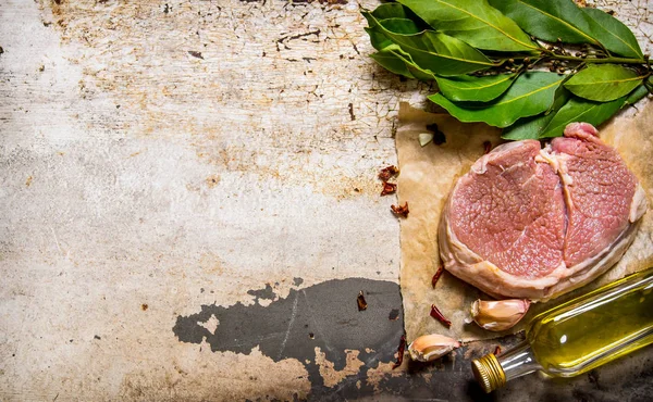 Carne fresca cruda con ajo y aceite en una tabla de madera . —  Fotos de Stock