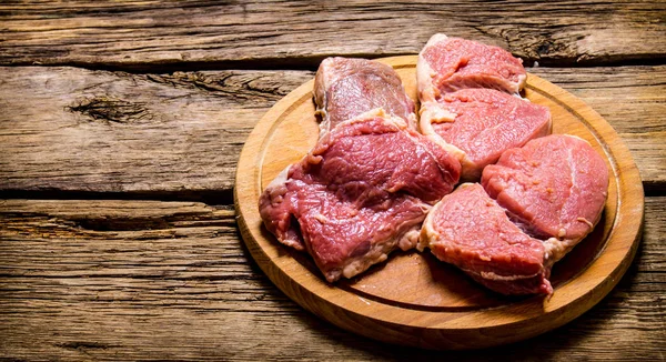 Ruwe vers vlees op snijplank. Op houten tafel. — Stockfoto
