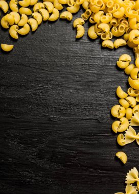 Makarna arka plan. Makarna kuru. Siyah ahşap arka plan üzerine.