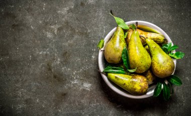 Yaprakları ile kase taze armut. 