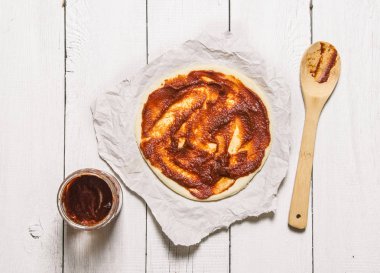 Domates soslu pizza hamuru. Beyaz ahşap arka plan üzerinde.