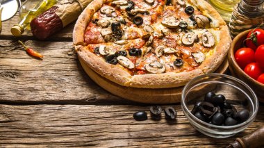 İtalyan pizza ve farklı malzemeler - et, mantar, domates ve zeytin yağı. 