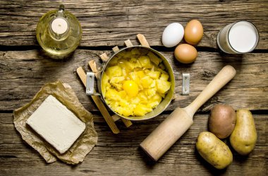 Patates püresi - yumurta, süt, tereyağı ve patateslerin üzerine ahşap arka plan için malzemeler.