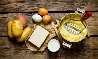 Patates püresi - yumurta, süt, tereyağı ve patateslerin üzerine ahşap arka plan için malzemeler.