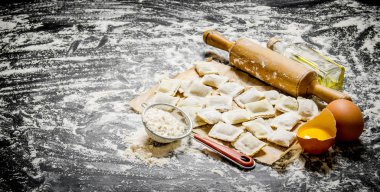 Yumurta, un ve bir oklava ile ham ev yapımı mantı. 