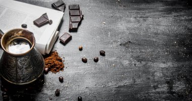 Demlenmiş kahve taze gazete ve bitter çikolata ile.