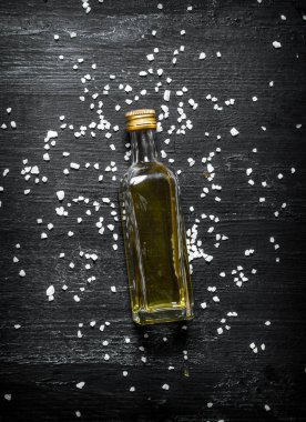  bir şişe zeytinyağı. Rustik siyah arka plan üzerine.