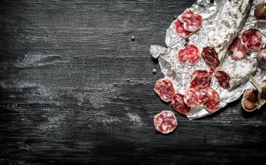 Folyo üzerinde baharatlar ile baharatlı salam. 