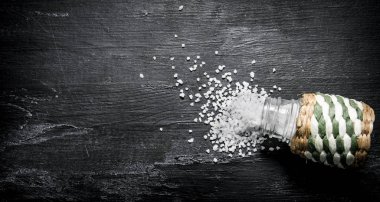 Saltcellar kaba tuz. Rustik siyah arka plan üzerine.