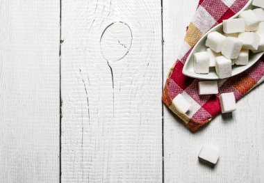 Rafine şeker Kupası'nda. Beyaz ahşap arka plan üzerinde.