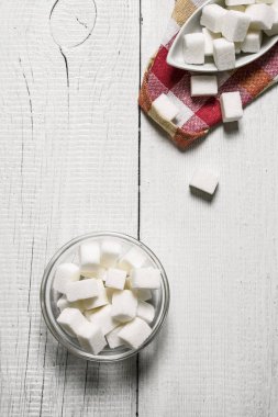 Rafine şeker Kupası'nda. Beyaz ahşap arka plan üzerinde.