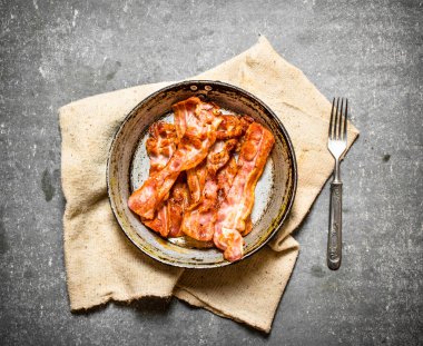 Kumaş bir tavada kızarmış domuz pastırması.