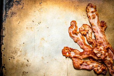 Kızarmış domuz pastırması. Eski rustik arka plan üzerinde.