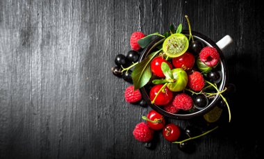 Çilek bir kupa. Siyah ahşap arka plan üzerine.