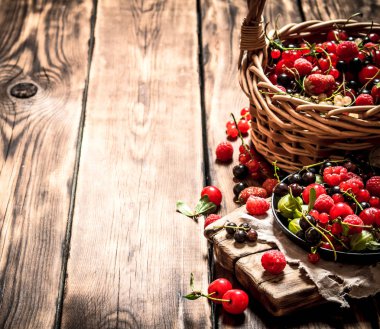 Eski bir sepet içinde taze çilek. Ahşap masa.