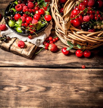 Eski bir sepet içinde taze çilek. Ahşap masa.