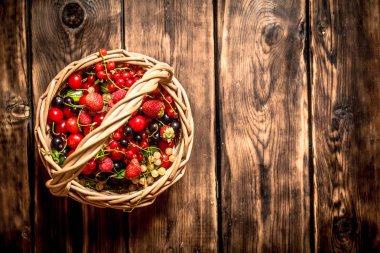 Eski bir sepet içinde taze çilek. Ahşap masa.
