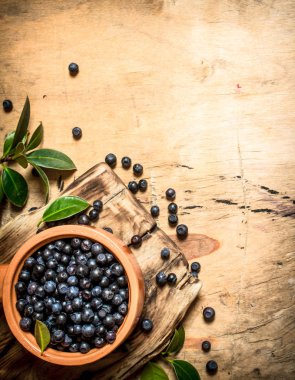 Bir fincan taze yaban mersini. Ahşap masa.