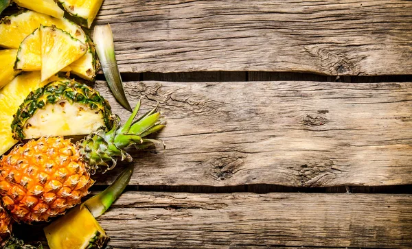 Vers gesneden ananas met geheel. Op houten achtergrond. — Stockfoto