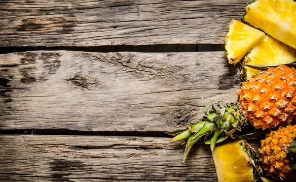 Vers gesneden ananas met geheel. Op houten achtergrond. — Stockfoto