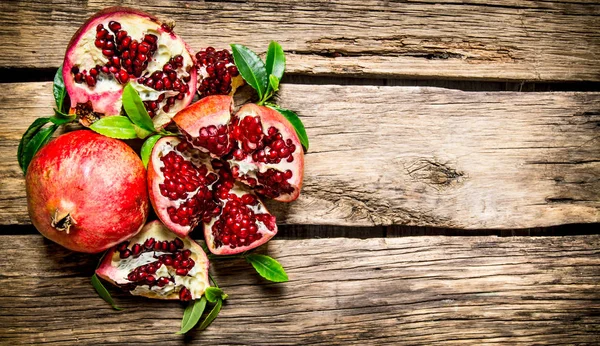 Fresh red pomegranate with leaves. On wooden background. — Stock Photo, Image