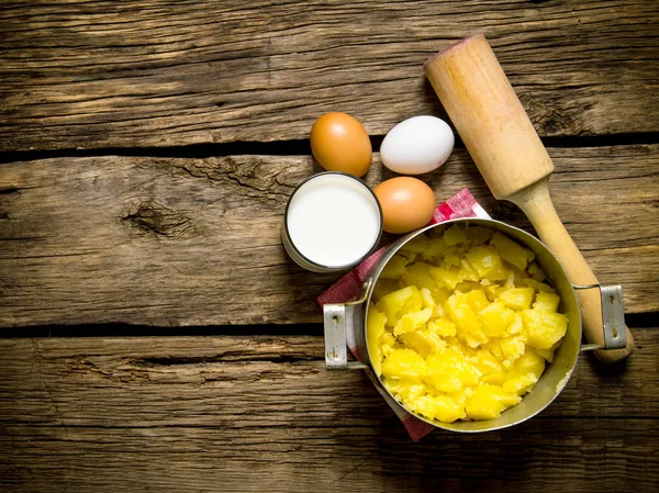 Ingredientes para puré de papas: huevos, leche, mantequilla y papas sobre fondo de madera. Espacio libre para texto . — Foto de Stock