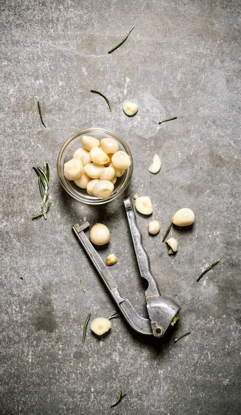 Geschälter Knoblauch in einer Glasschüssel und Knoblauch pressen. — Stockfoto