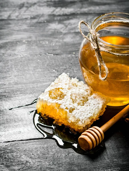Fundo de mel. Pente de mel natural e um jarro de vidro . — Fotografia de Stock
