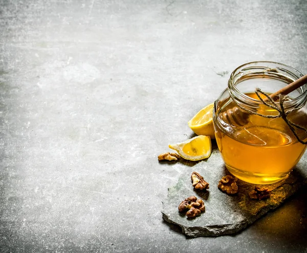 Miel natural en tarro, limón y nueces . — Foto de Stock