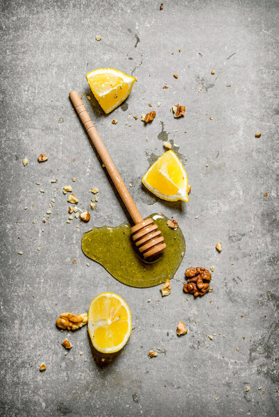 Honey background. Natural honey with slices of lemon and walnuts. 