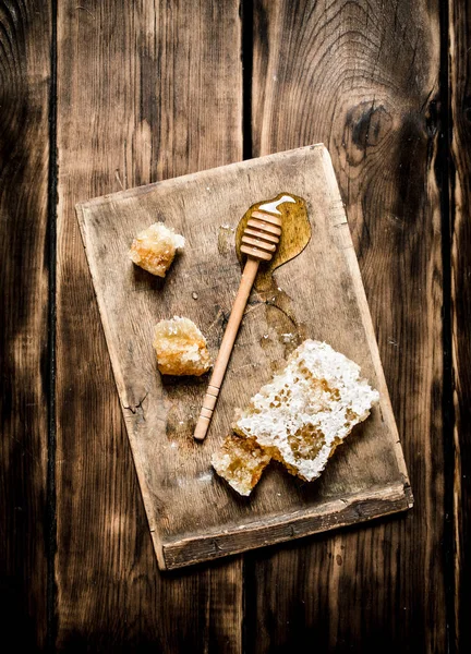 Mel natural em favos de mel com uma colher na placa . — Fotografia de Stock
