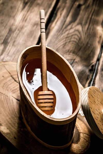 Naturhonig im Holzfass mit Löffel. — Stockfoto