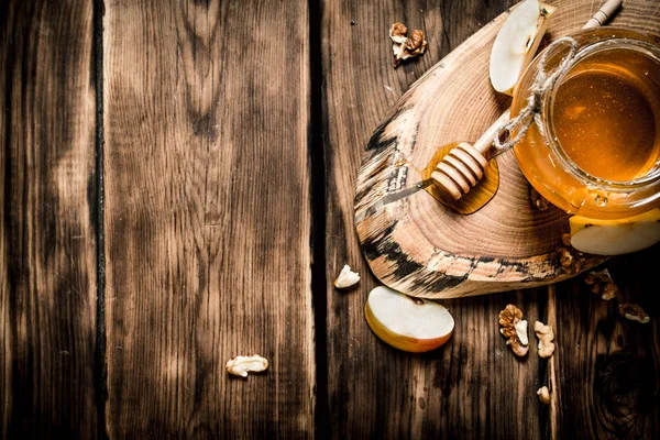 Honey in a jar with nuts and Apple slices. — Stock Photo, Image