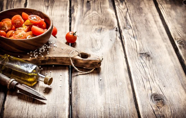 Tomates frescos em uma tigela de madeira com azeite . — Fotografia de Stock