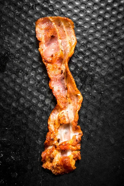 Pruh smažené slaniny v pánvi. — Stock fotografie