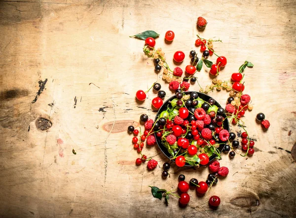 Wild berries in the old plate. On wooden table. — Stock Photo, Image