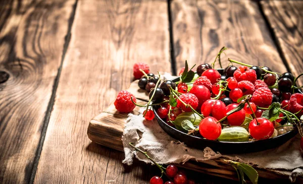 Wild berries in the old plate on the Board.