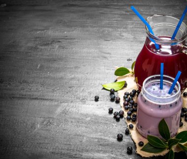 Yaban mersini smoothies ve eski kumaş üzerine taze meyve suyu.