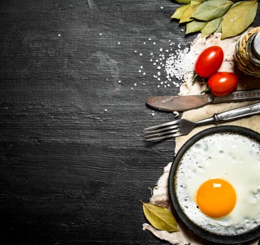 Sahanda yumurta domates ve tuz. Siyah ahşap arka plan üzerine.