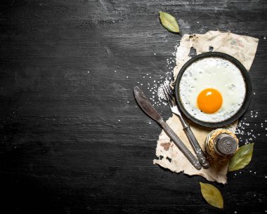 Sahanda yumurta baharatlar ile. Siyah ahşap arka plan üzerine.