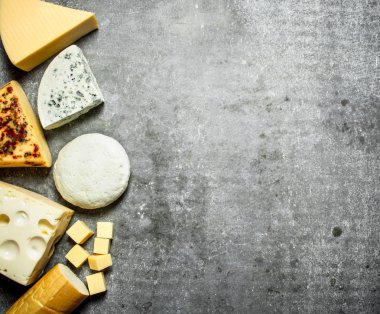 Peynir farklı türleri. Taş masanın üzerine.