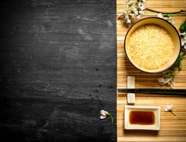 Pirinç, soya sosu ve kiraz dallar ile kase.