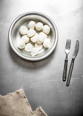 Mozzarella peyniri ile bir bıçak ve çatal.