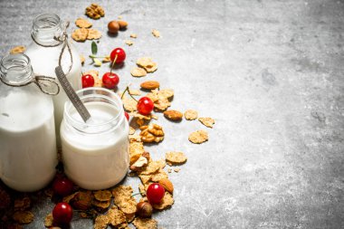 Fitness gıda. Yabani çilek ve süt şişeleri ile müsli.