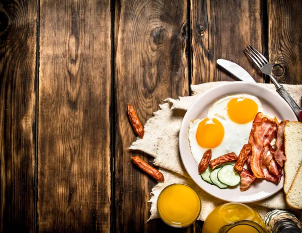 Fried bacon with eggs and orange juice. — Stock Photo, Image