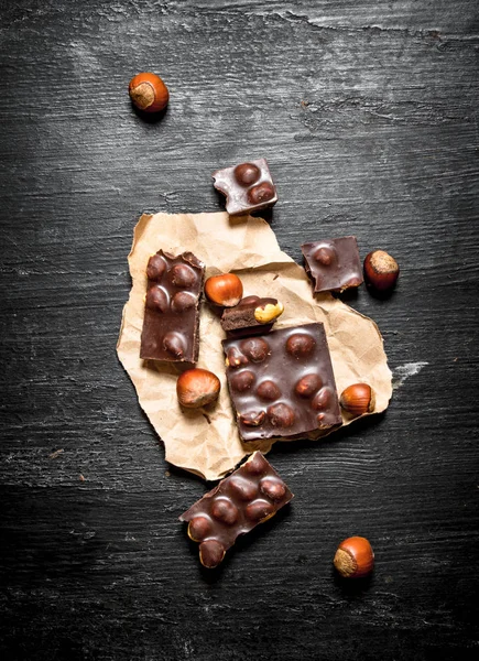 Die Stücke Schokolade mit ganzen Haselnüssen . — Stockfoto