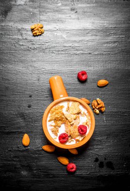 Meyveler, fındık ve kabın içinde süt ile müsli.