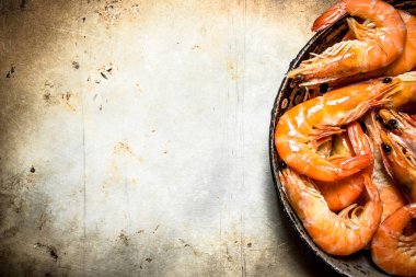 Eski bir tavada karides.